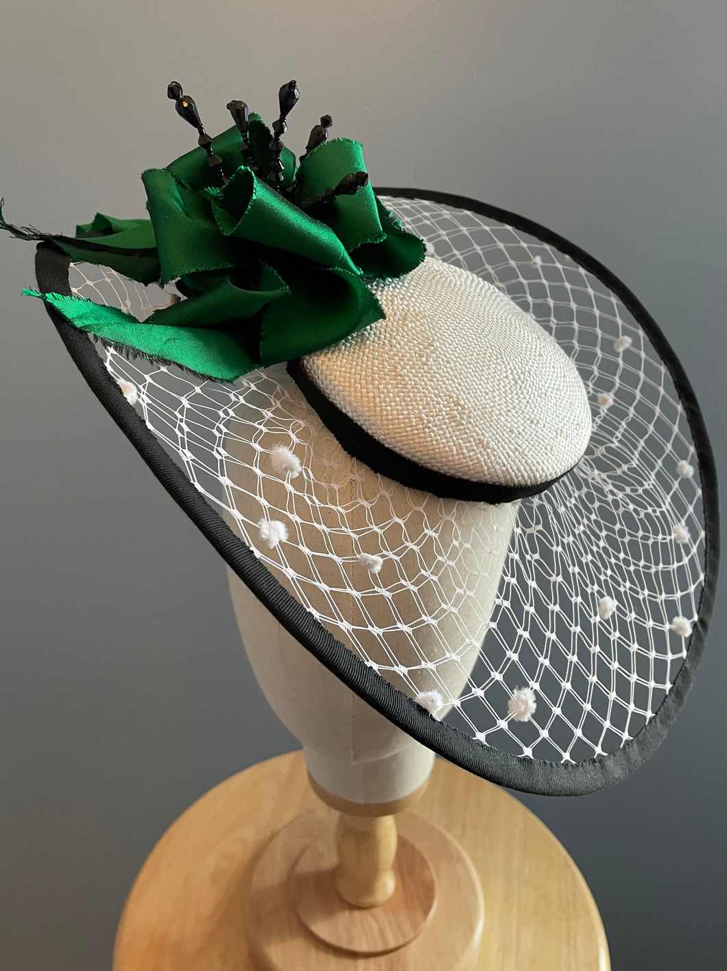 White veiled brim with emerald green and black trim